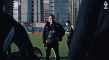 a man stands on a field wearing a prestige shirt