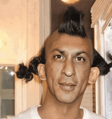 a man with a mohawk and two pigtails on his head