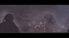 a large monster is destroying a city with a soldier holding a gun in the foreground