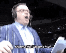 a man in a suit and headphones is singing mamma mia