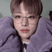 a close up of a person wearing glasses and a tie