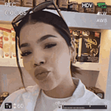 a woman wearing sunglasses is being recorded on a camera with a rec time of 0:00:05