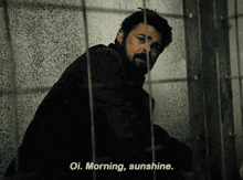 a man with a beard is behind bars and says oi morning sunshine