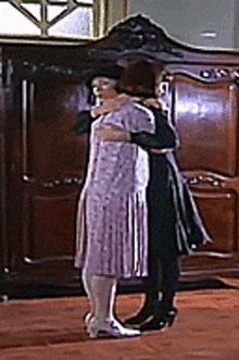 two women are hugging each other in a room
