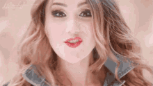 a close up of a woman 's face with red lips and a denim jacket on
