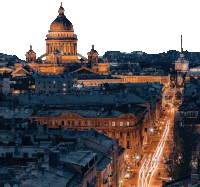 an aerial view of a city at night with a large dome in the background
