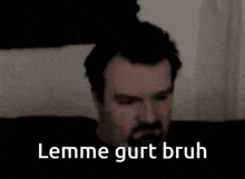 a man with a beard is laying on a bed with the words lemme gurt bruh written on the bottom .