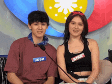 a man and a woman are sitting in front of a microphone and one of them has a name tag that says josh