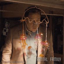 a man with jellyfish hanging from his jacket and rental family written on the bottom right