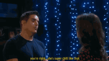 a man and a woman are talking in front of a string of lights and the woman says you 're right