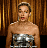 a woman in a strapless dress says " don 't worry though i 'm sober " in front of a microphone