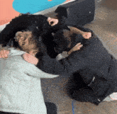 a woman is laying on the floor while a man is kneeling next to her