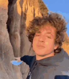 a young man with curly hair is wearing a blue mask