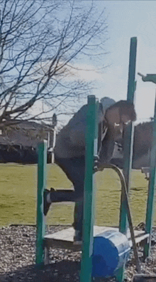 a person is doing push ups on a playground equipment .