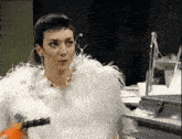 a woman with short hair wearing a white fur coat