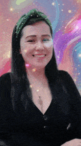 a woman wearing a green headband and a black top smiles