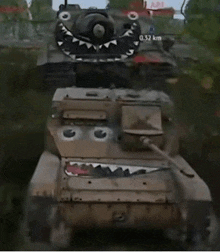 a tank with a shark face painted on it is driving past another tank