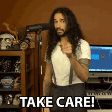 a man with long hair and suspenders is pointing at the camera and says take care !