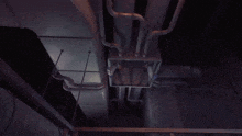 a clown is hanging upside down from a pipe in a room