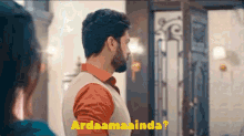 a man with a beard is standing in front of a door and says ardaamaaina ?