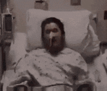 a man is laying in a hospital bed with a candle in front of him .