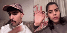 a man and a woman are sitting next to each other on a couch and waving at the camera .