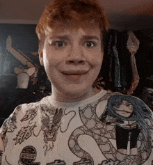 a man with red hair is wearing a shirt with a dragon and a girl on it