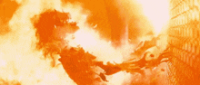 a person is flying through the air in front of a large explosion .