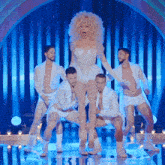 a woman in a white dress is surrounded by men