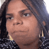 a close up of a woman 's face with braids .