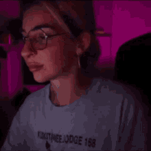 a woman wearing glasses is covering her face with her hand