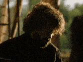 a man with curly hair and a beard wearing a black shirt