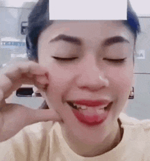 a woman is holding a piece of paper to her face .