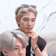 a man with sunglasses on his head is sitting next to another man with gray hair .