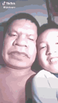 a man and a boy are standing next to each other and smiling .