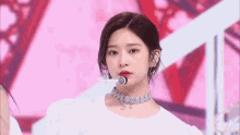 a close up of a woman wearing a choker necklace and earrings on a stage .