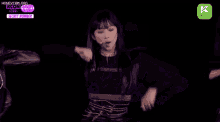 a woman is dancing on a stage with a microphone in her mouth .