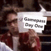 a man is holding a card that says gamepass day one