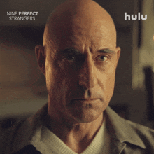 an advertisement for nine perfect strangers shows a bald man with a serious look on his face