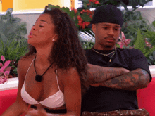 a man and a woman are sitting back to back on a red couch