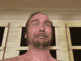 a shirtless man with a beard is making a funny face