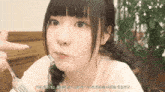 a girl is holding a fork in her hand and eating something .