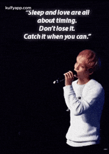 a young man is holding a microphone with a quote on it