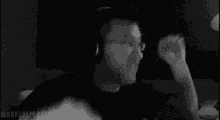 a man wearing headphones is dancing in a black and white photo .