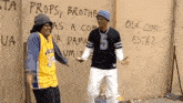 two men standing in front of a wall that says props brother