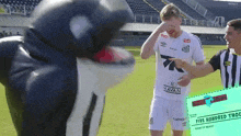 a man in a havan jersey is standing next to a mascot