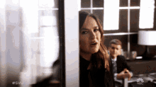 a woman behind a glass door with the words #svu on the bottom