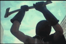 a man in a black mask is holding a large hammer over his head