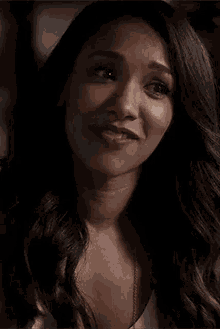 a woman is holding a piece of wood in her hand and smiling .