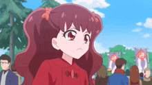 a girl in a red dress stands in a crowd
